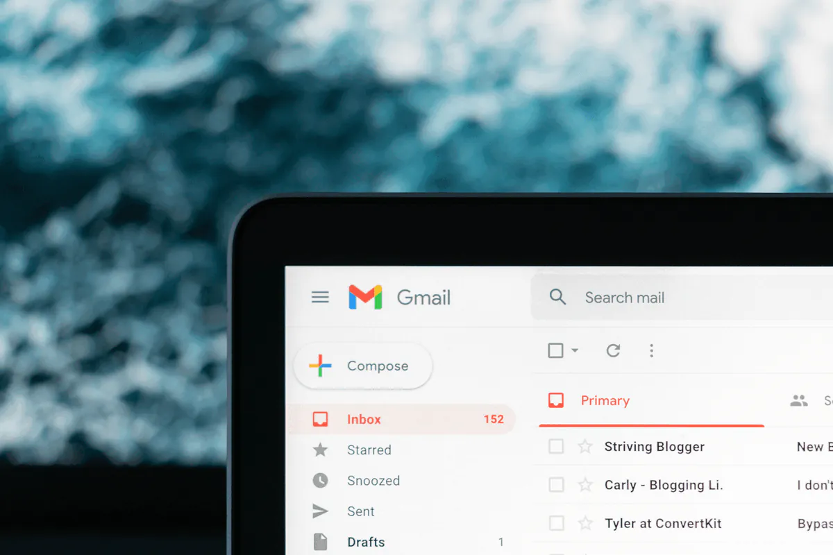Gmail inbox open on a laptop screen showing unread emails, How to write an invoice email with a free email invoice template for businesses and freelancers.