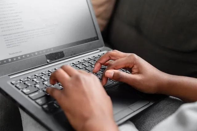 Close-up of a person typing on a laptop keyboard, emphasizing the role of technology in managing contract lifecycle management (CLM) stages and digital contract management.