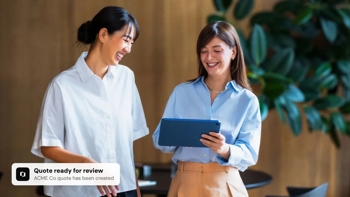 Two colleagues reviewing a quote on a tablet, with a Portant notification that a quote is ready for review